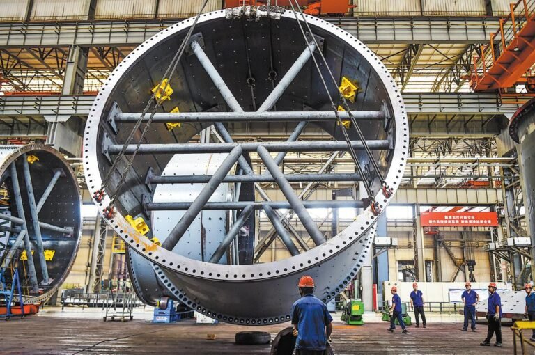 Workers hoist an oversized mining mill cylinder for export at a workshop of CITIC Heavy Industries in Luoyang, Henan province, on Tuesday. HUANG ZHENGWEI / FOR CHINA DAILY