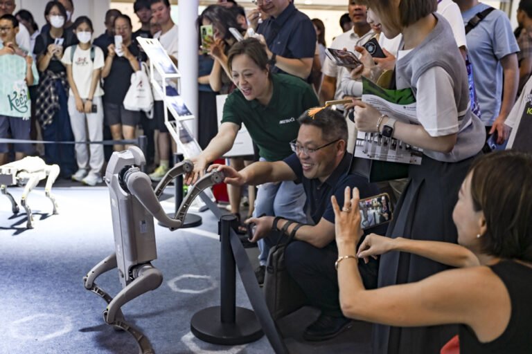 Visitors interact with a robot dog at the 2025 World AI Conference (WAIC) in East China's Shanghai, July 29, 2025. [Photo/Xinhua]