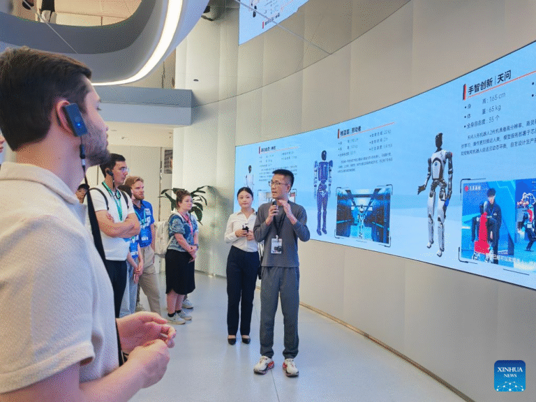 Gao Yongkai, a graduate student from Hong Kong University of Science and Technology (Guangzhou), introduces humanoid robots to youth delegates in Wuhan, central China's Hubei Province, June 14, 2026. (Xinhua/Yue Wenwan)