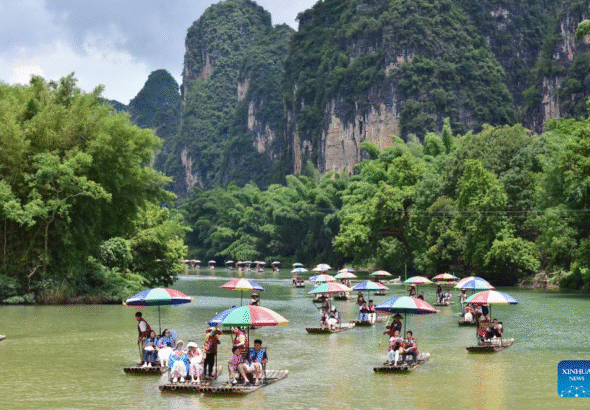 People enjoy rafting on Yulong River in Yangshuo County, Guilin City, south China's Guangxi Zhuang Autonomous Region, Aug. 2, 2026. (Photo by Liao Zuping/Xinhua)