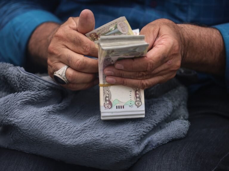 Iraq devalues dinar to ease cash crunch, leaving traders in limbo